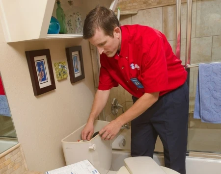 Mr. Rooter technician fixing a toilet