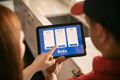 A customer pointing a option on a Mr. Rooter plumber's tablet