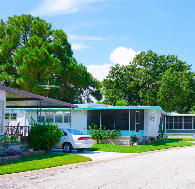 Mobile home park with green trees on a bright, sunny day.