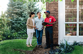 Mr. Rooter professional speaking with customers outside of their home.