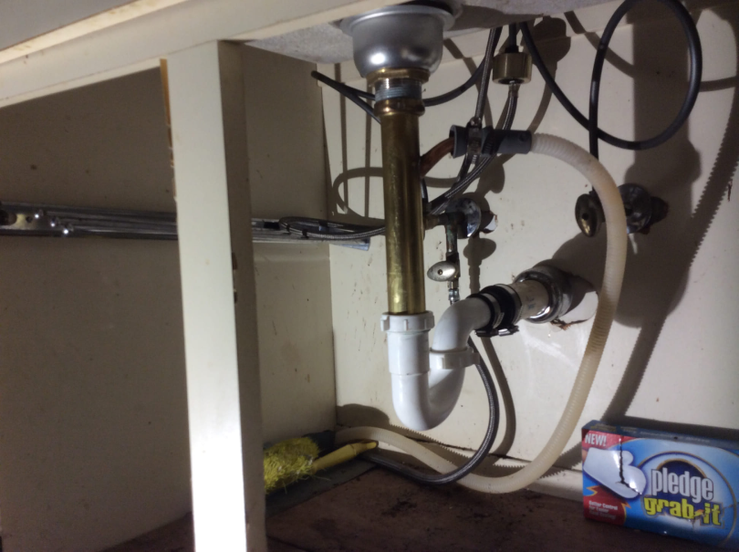 The drain pipe underneath a sink in a home receiving professional services for drain repair in the Hamptons, NY.