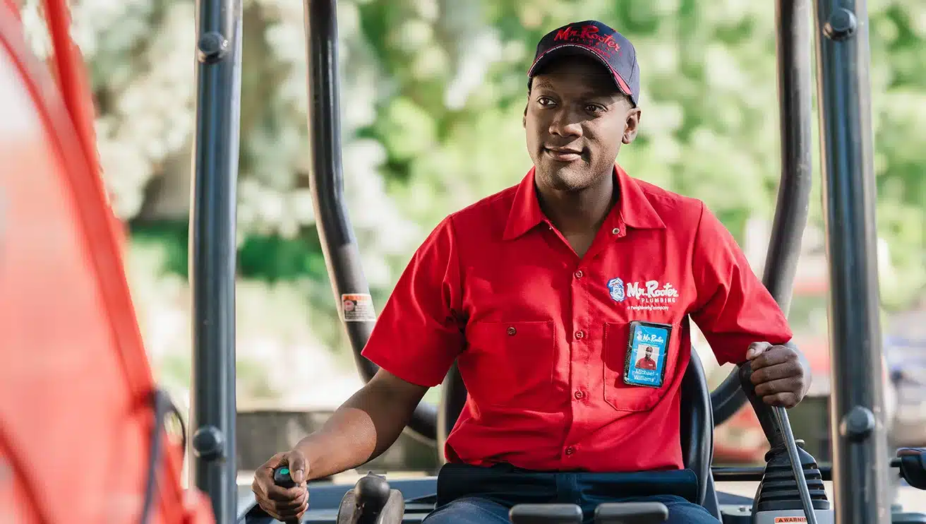Mr. Rooter technician driving machinery.