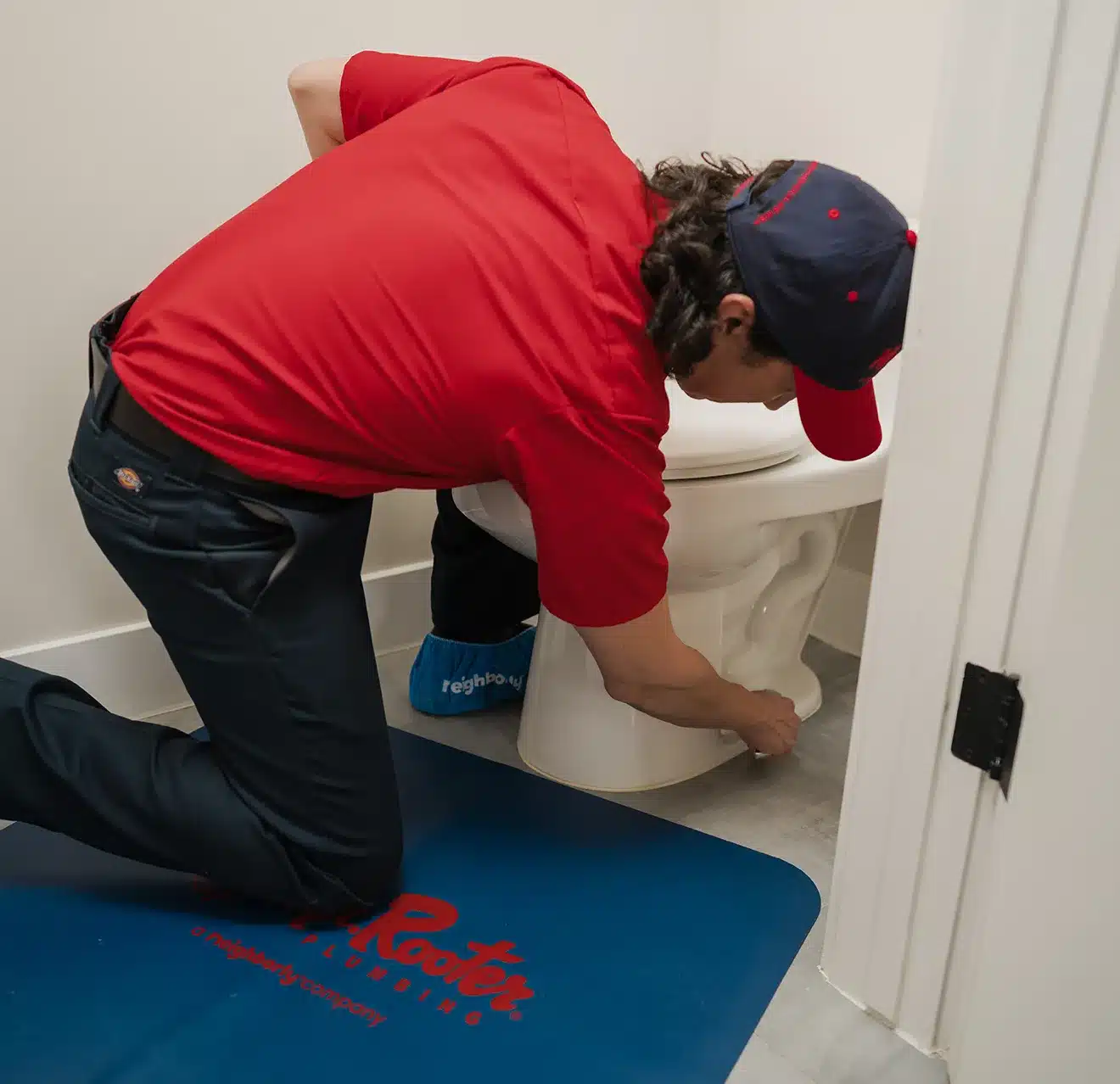 Mr. Rooter plumber performing a toilet repair service in Denver, CO.