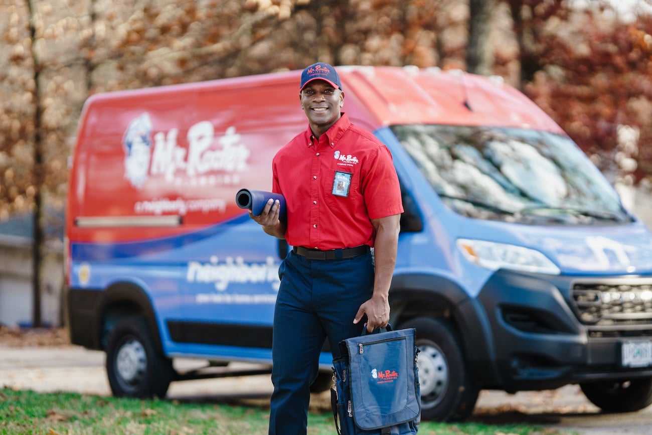 A Mr. Rooter proffesional in uniform walking up to a customer's home