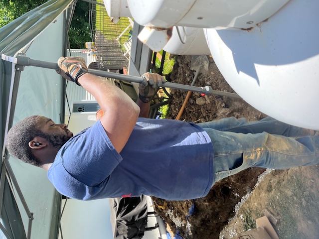 Mr. Rooter Plumber holding a digging bar.