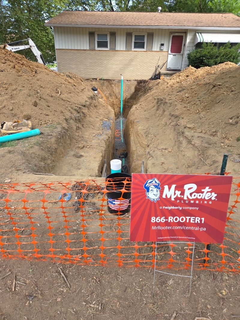 Red Mr. Rooter Plumbing sign with green PVC