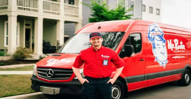  Mr. Rooter plumber standing in front of a work van before conducting gas line repairs.