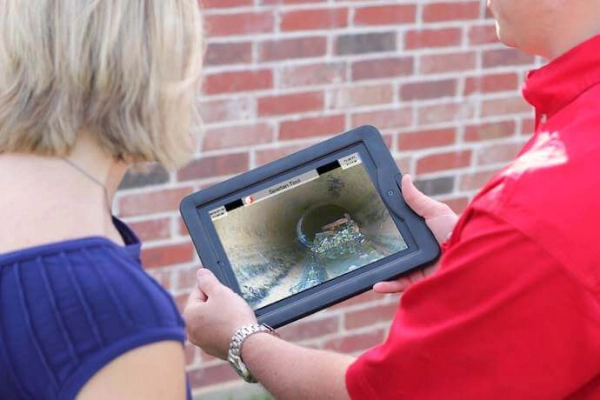 Mr. Rooter Plumbing showing a customer a drain camera on tablet