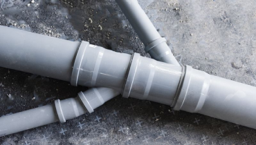 Drain piping, grey plastic pipes various diameters connecting into one stock photo
