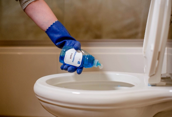 image showing a person adding soap to toilet bowl