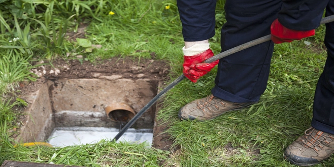 A man services a sewer line with a long tool. | Mr. Rooter® Plumbing of Virginia Beach