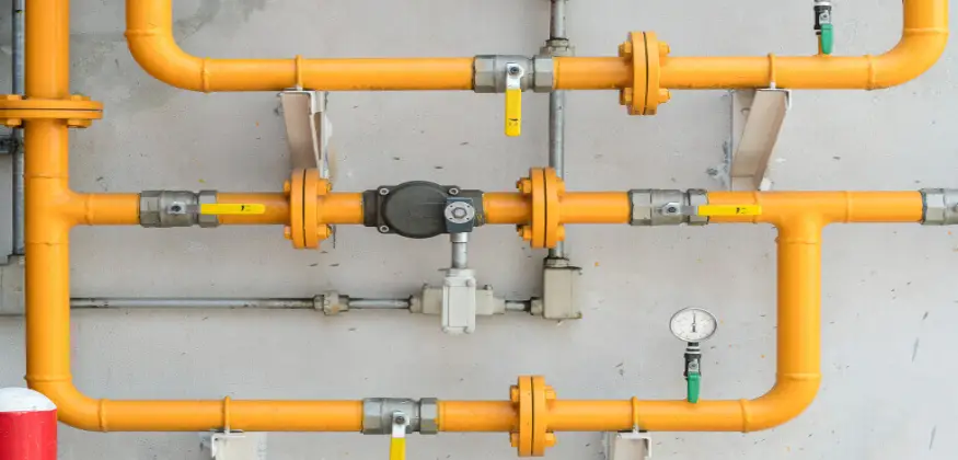 Yellow gas lines against a grey wall