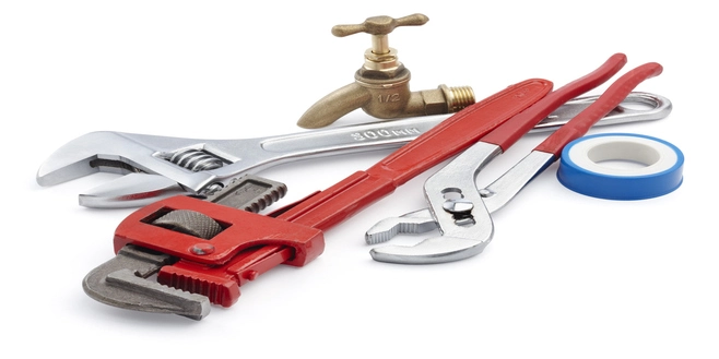 A stock photo of essential plumbing tools, including a wrench, pliers, and Teflon Tape.