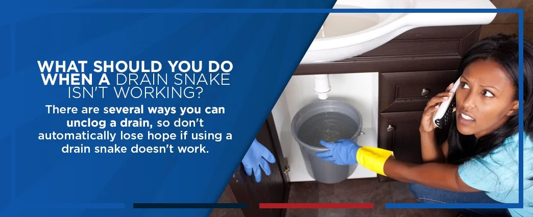 Bucket of water under sink with text about drain snakes