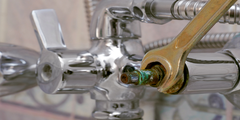 A wrench replaces a defective ceramic disc cartridge covered with limescale in shower mixer.
