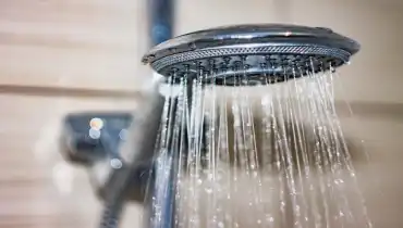 Silver shower head spraying water