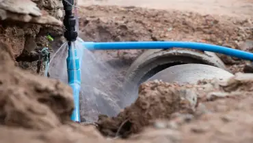 A broken water pipe that has been dug up leaks water. | Mr. Rooter Plumbing of Greater Charleston