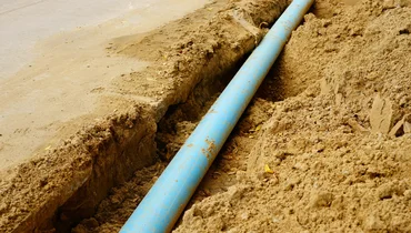 Long blue plastic sewer pipes in ground