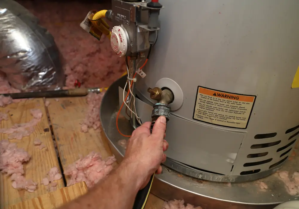 Gas Water Heater Getting Checked by Hand