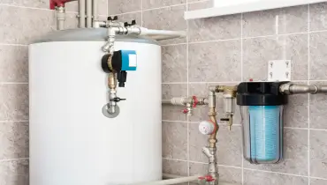 A water heater is shown with various pipes and valves connected to it. | Mr. Rooter® Plumbing of Greater Charleston