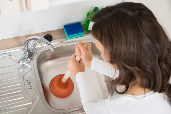 Woman plunging kitchen sink