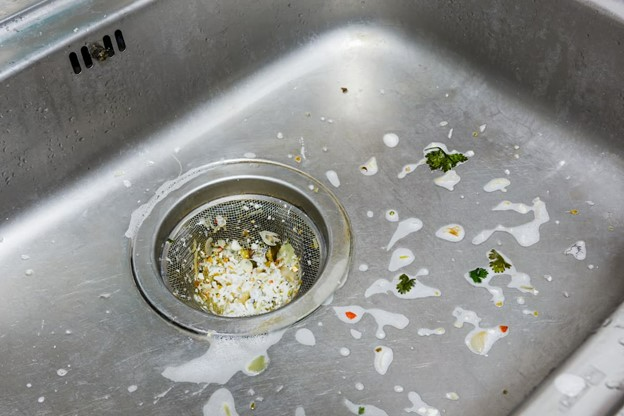 Food particles trapped in the kitchen sink forming a clog