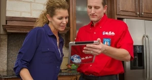 One of our plumbers in Springfield, OH talking to a customer about plumbing services with a tablet