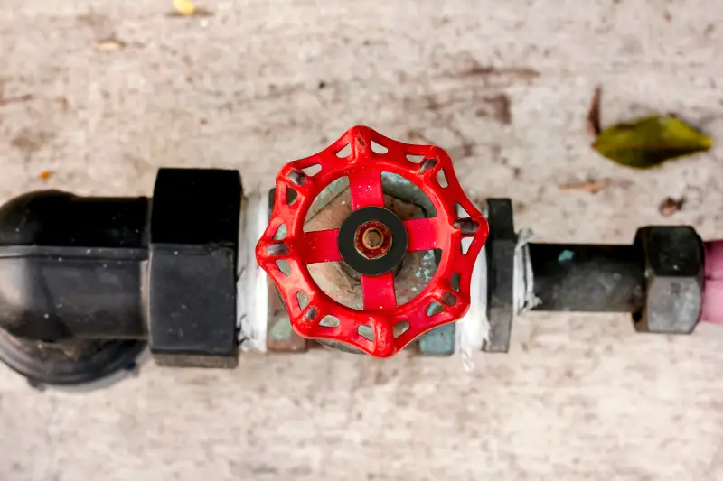 Close-up of a home&rsquo;s main water shut-off valve in a residential plumbing line, highlighting the importance of knowing its location before a hurricane.