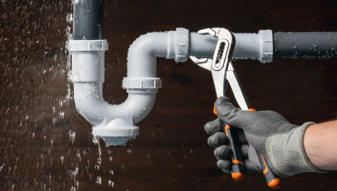 Close up of a plumber's hand fixing a water leak | Mr. Rooter Plumbing Yavapi, Coconino, and Maricopa Counties.