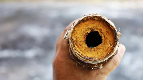 Cross-section of a drain pipe clogged with hardened grout dust and cement