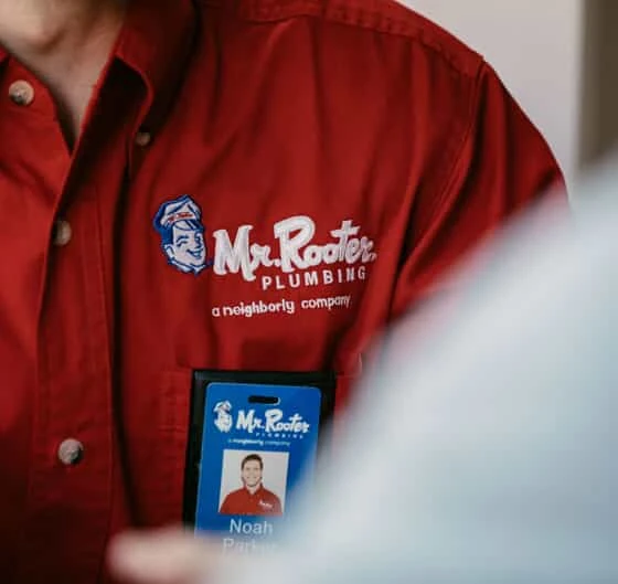 Close up of a Mr. Rooter employee's name tag on his shirt.