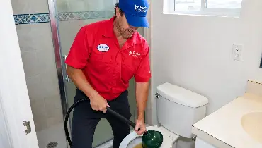 Mr. Rooter professional drain snaking a toilet.