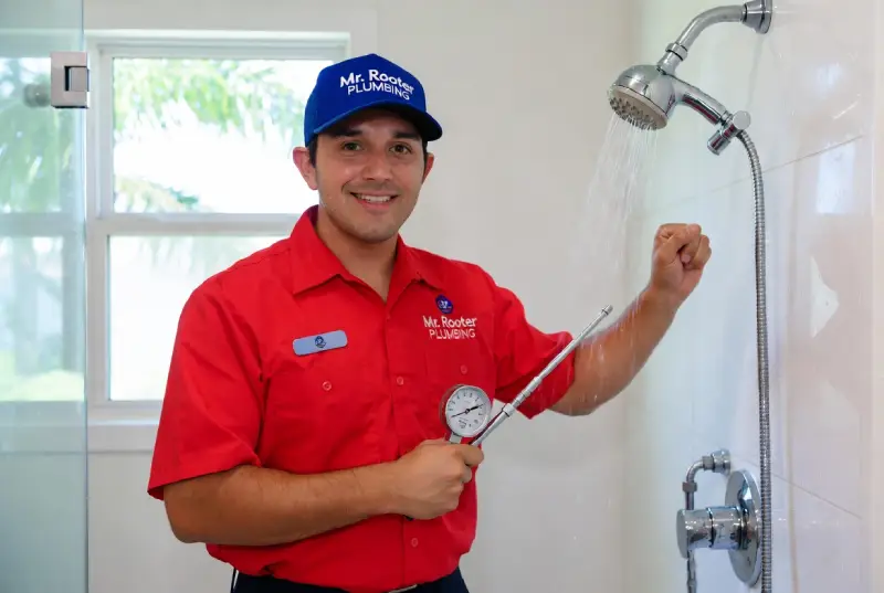 Mr. Rooter professional working on fixing water pressure in a shower.