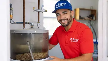 Mr. Rooter professional fixing a water heater.
