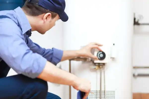 Repairman adjusting a water heater at a customers home
