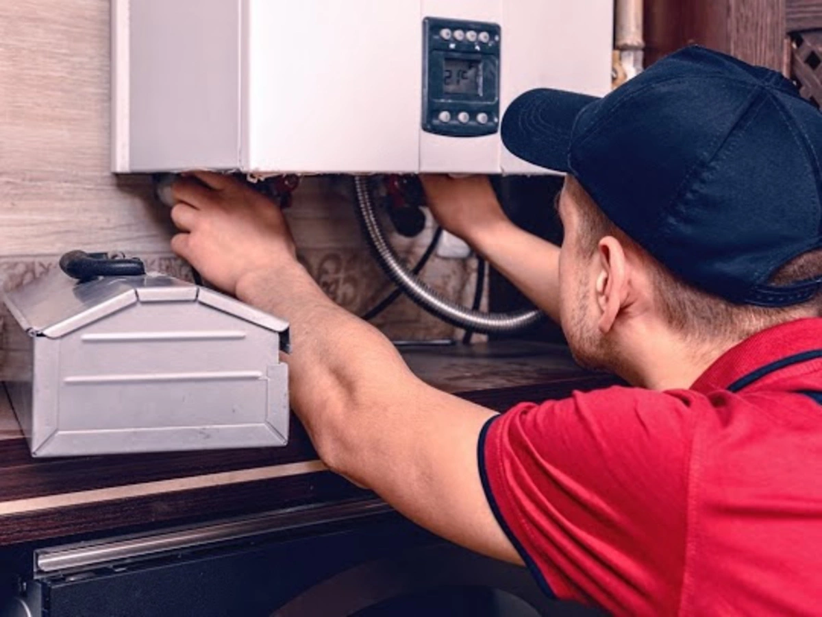 A professional plumber servicing a water heater unit in Memphis