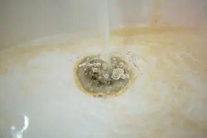 Water pouring into a clogged tub in need of drain cleaning