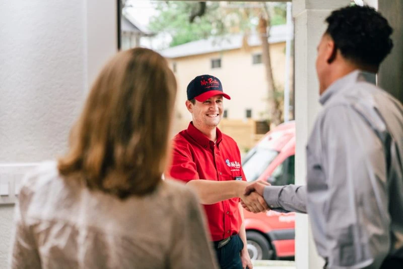 Mr. Rooter service professional greeting customers before water line repair service