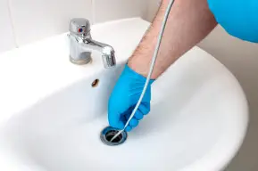 Cedar City plumber completing a drain cleaning with a drain snake