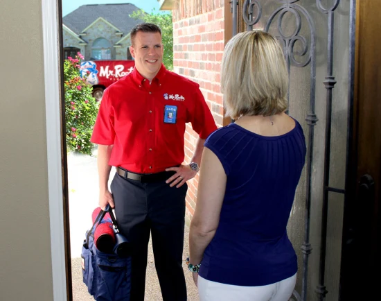 Mr. Rooter technician at front door talking with customer
