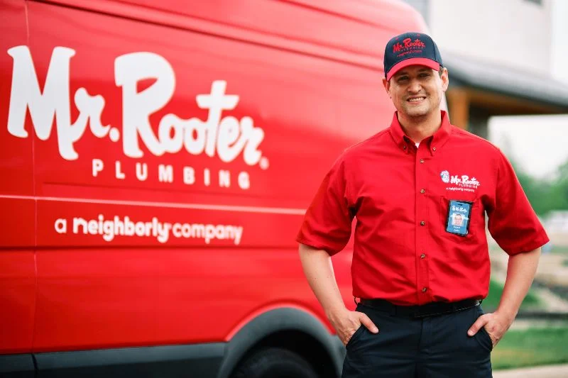 Mr. Rooter plumber standing beside his van in Centralia, MO.