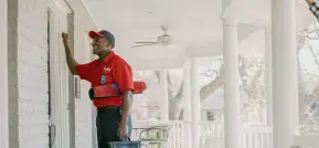 Mr. Rooter water heater plumber smiling and knocking on a customer's door