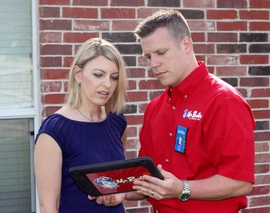 Mr. Rooter Plumber Showing Tablet to the Customer