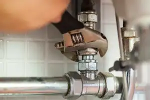 The hand of one of our plumbers in Sarasota, FL, tightening a plumbing fixture