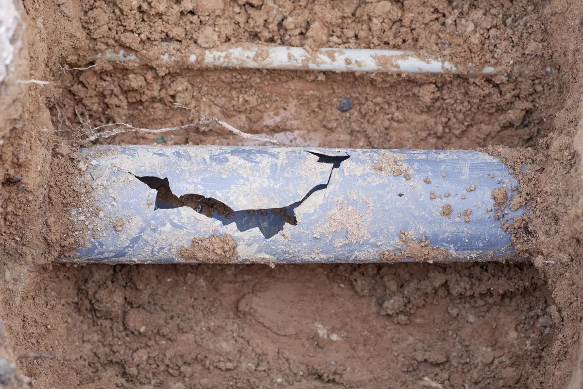 A cracked sewer line in a hole that has been dug for the purposes of sewer line repair in San Antonio.