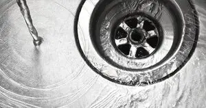 Water flowing into drain in a steel sink