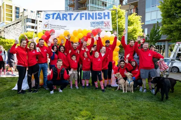 Mr. Rooter of Vancouver group photo in front of 5K Start/Finish banner and balloons.