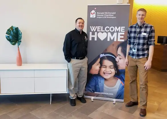 Mr. Rooter Plumbing Operations Manager Jeremy West, with RMHC Director of Building Operations Andy Olds beside RMHC banner.